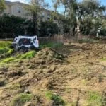 The Bobcat clearing and leveling the site.